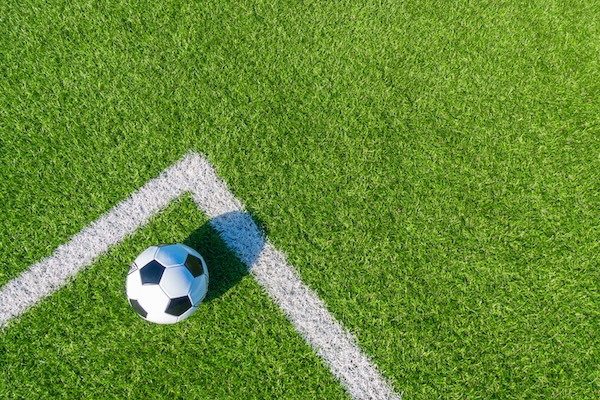 Soccer football sport background. Soccer ball on green artificial grass turf field with white line. Top view